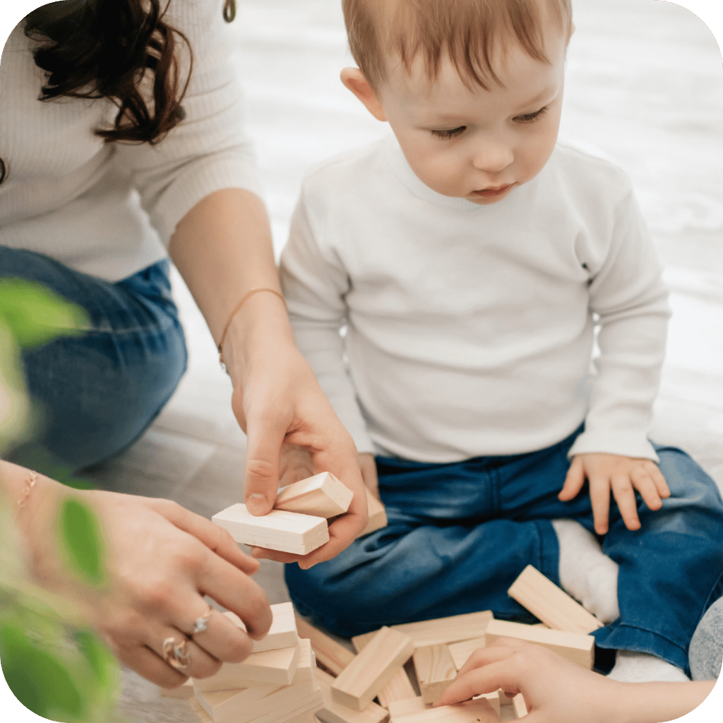 Niño de 2 años jugando con piezas de madera.