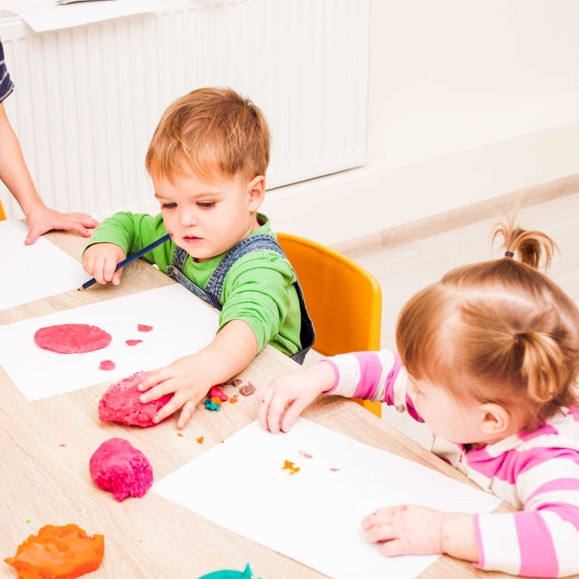 Niños de infantil jugando con plastilina.